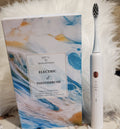 Electric toothbrush with packaging featuring a marble design on a textured surface.